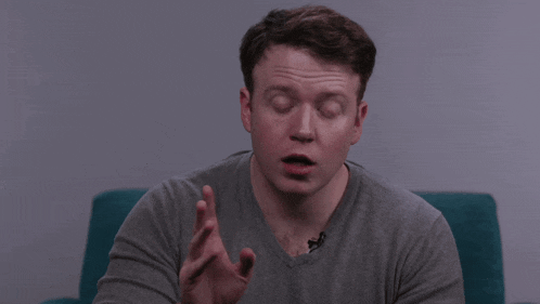a man in a grey shirt is saying fuck