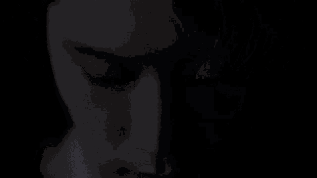 a close up of a man 's face with his eyes closed in the dark .