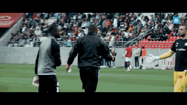 two soccer players are walking on the field and one of them is wearing a jersey that says united