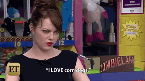a woman says " i love corn dogs " in front of a sign that says zombieland .