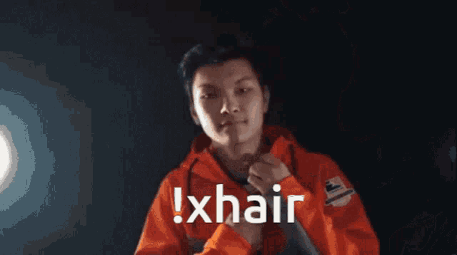 a man in an orange jacket says ! xhair in white letters