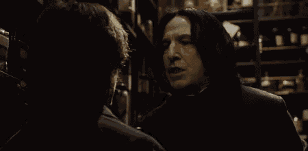 a man is talking to another man in a dark room .