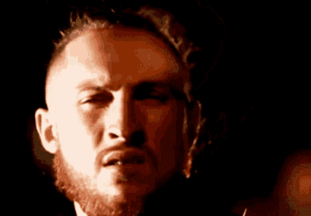 a man with a beard is making a funny face