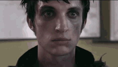 a close up of a man 's face with a black eye and a bite on his lip .