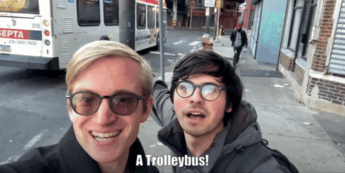 two men are posing for a picture with the words a trolleybus below them