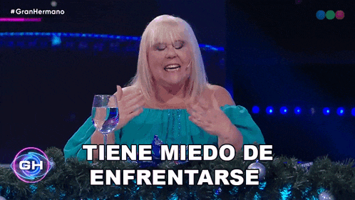 a woman sitting at a table with a glass of water and the words tiene miedo de enfrentarse