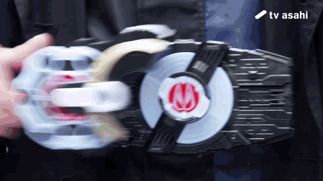 a person is holding a toy with a tv asahi logo in the corner