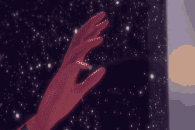 a hand in a red glove is reaching out towards the stars in the night sky .