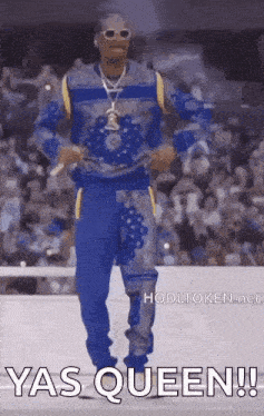 snoop dogg is dancing in front of a crowd while wearing a blue and gray outfit .