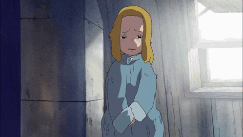 a girl in a blue shirt is crying in a room