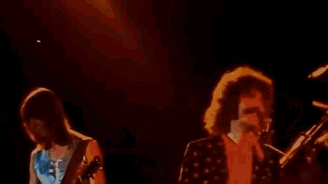 a group of people are playing instruments on a stage in front of microphones .