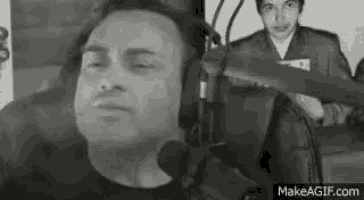 a man wearing headphones and a microphone is sitting in front of a microphone in a black and white photo .