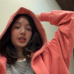 a woman wearing a pink hoodie and striped shirt