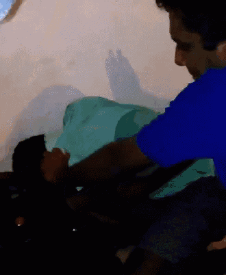 a man in a blue shirt is holding a woman in a green blanket
