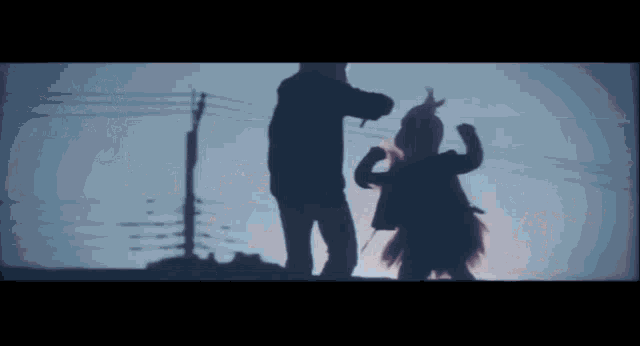 a man and a little girl are standing next to each other in a dark room .