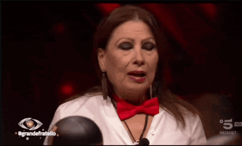 a woman wearing a red bow tie is crying on a tv show