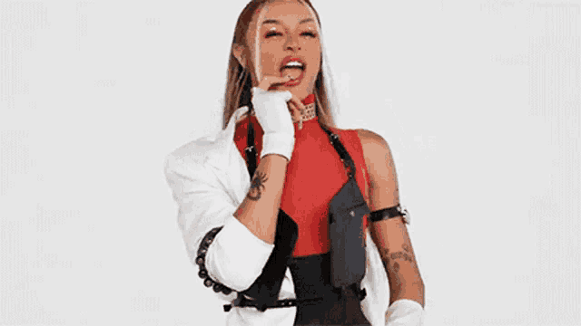 a woman is wearing a red top and a white jacket and gloves .