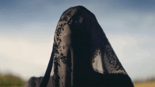 a woman wearing a black veil covering her face