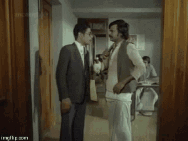 two men are standing next to each other in a room and one of them is saying ellam eyewaas .