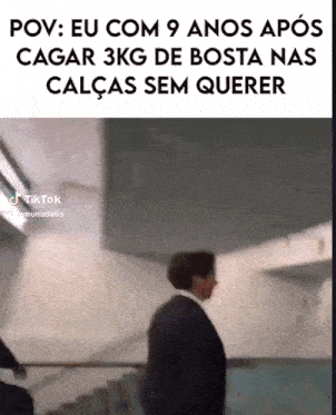 a man in a suit is walking down a staircase with the caption pov eu com 9 anos após cagar 3kg