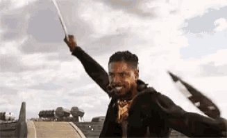 a man is holding a sword in the air in a field .