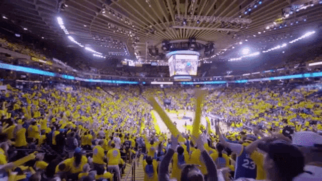 a crowd of people in a stadium watching a basketball game with a player wearing the number 23