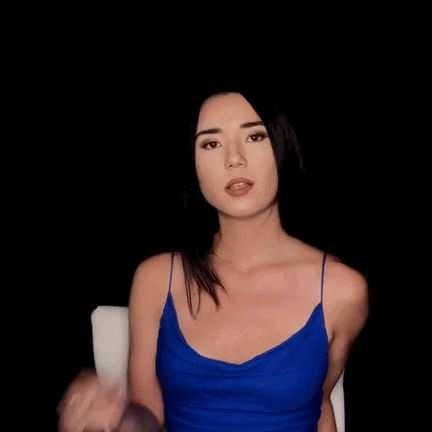 the woman is wearing a blue tank top and sitting in a chair .