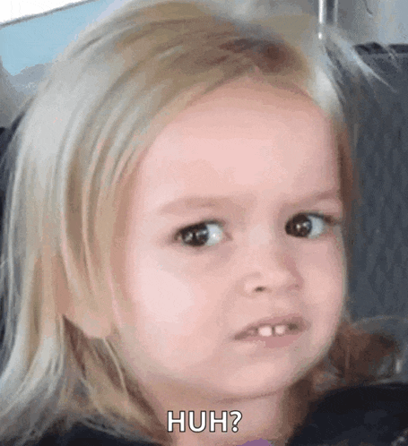 a little girl with blonde hair is making a funny face and saying huh ?