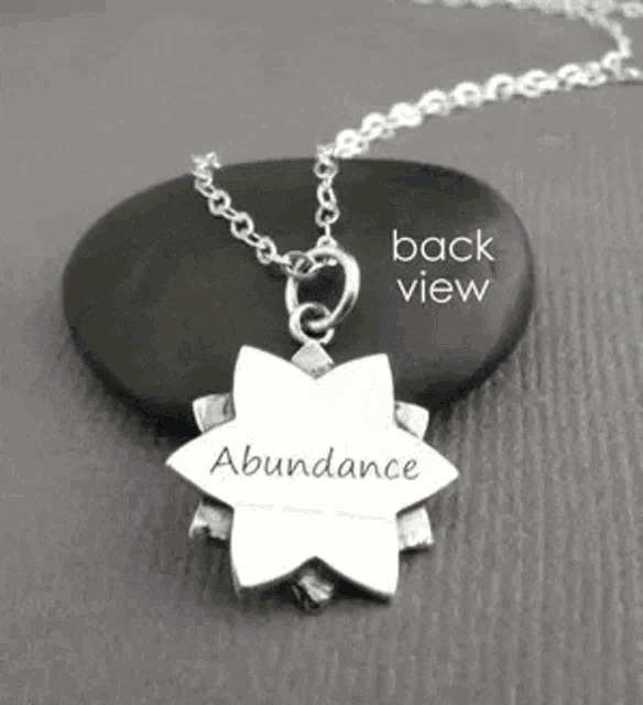 a necklace with a pendant that says abundance on it