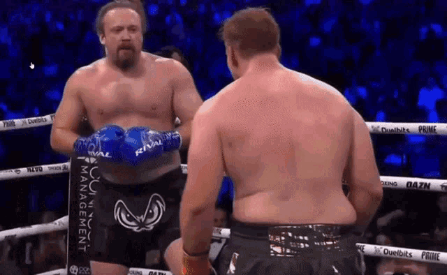 two men in boxing gloves are standing in a ring with the word rival on their shorts