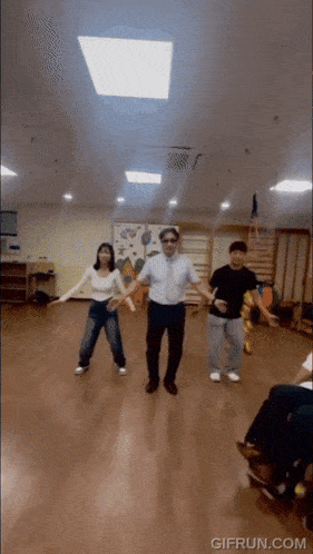 a group of people are dancing in a room with a gifrun.com watermark