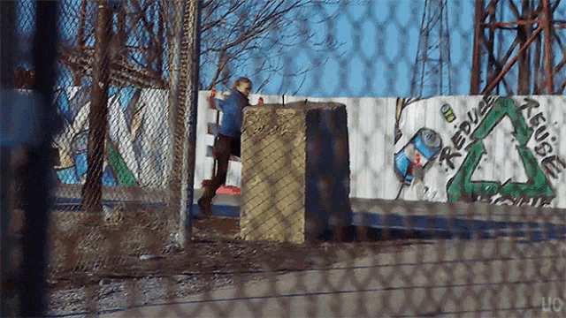 a fence with graffiti on it that says reuse on it