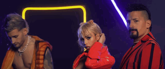 a woman in a red jacket is surrounded by two men