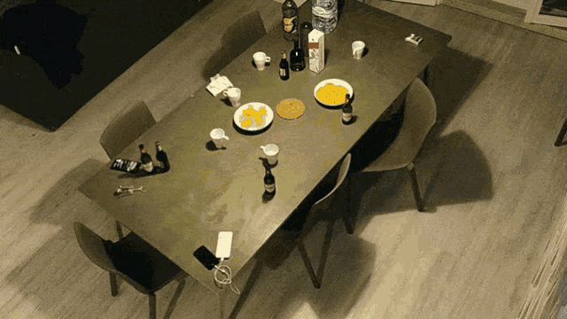 a table with a bottle of orange juice and a bowl of food on it