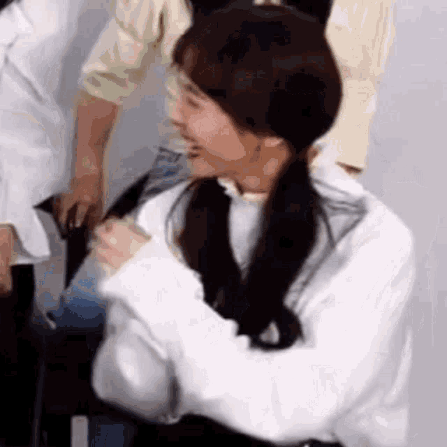 a girl is sitting in a chair with her arms crossed and smiling .