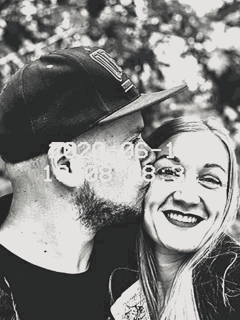 a black and white photo of a man kissing a woman on the cheek with the date of september 1st