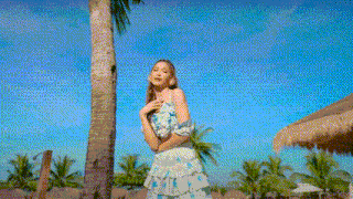 a woman in a swimsuit is standing next to a pool and smiling .