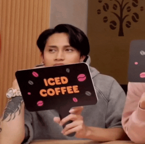 a man is holding a sign that says iced coffee on it