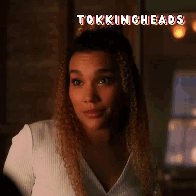 a woman with curly hair is smiling with the words tokingheads behind her