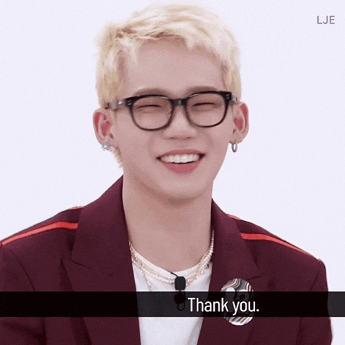 a young man wearing glasses and a white shirt says " thank you "