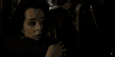 a couple of women are standing next to each other in the dark .