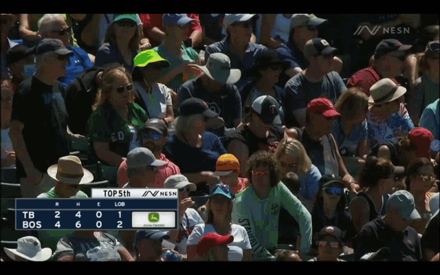 a crowd of people watching a baseball game with a scoreboard that says " top 5th "