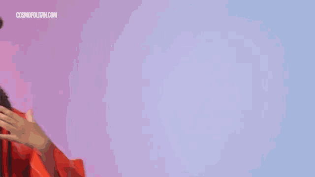 a woman with braids and hoop earrings is wearing an orange jacket