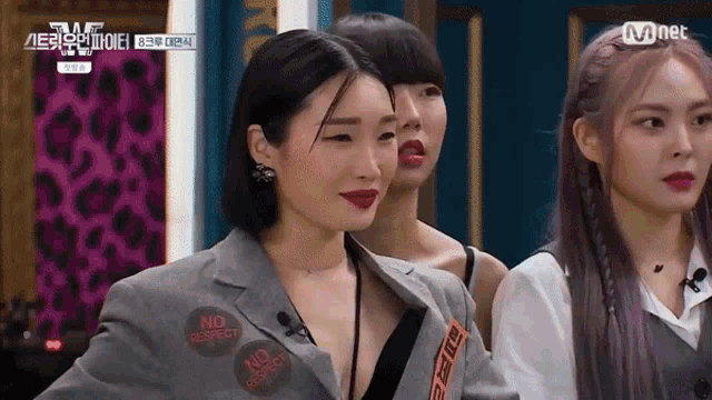 a group of women are standing next to each other and one of them is wearing a jacket with stickers on it that say no respect .