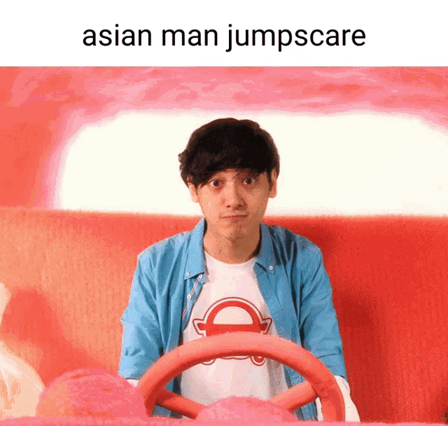 a man in a blue shirt is sitting in a pink car with the words asian man jumpscare below him