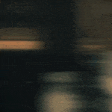 a blurry picture of a woman sitting on a couch in a dark room
