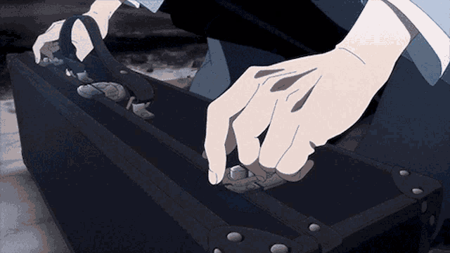 a person is opening a black briefcase with their hand