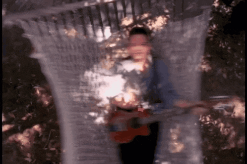 a blurry picture of a person playing a guitar