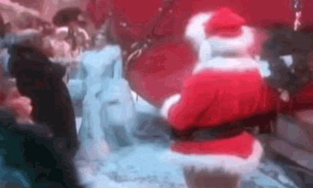 a blurry picture of santa claus standing in front of a crowd at a party .