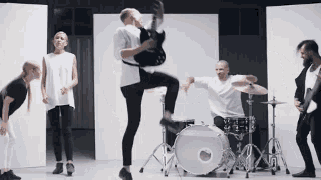 a man is jumping in the air with a guitar in his hand